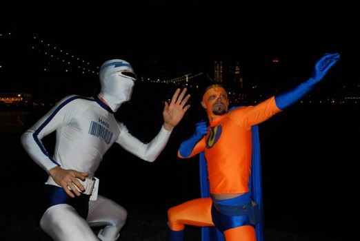 Unemployed Man (right) and Captain Generica (left) strike a pose in DUMBO, Brooklyn, with Manhattan's financial district in the background. 